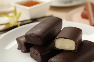 Photo of Glazed vanilla curd cheese bars served on table, closeup