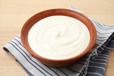 Photo of Bowl of fresh yogurt and napkin on table