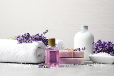 Photo of Cosmetic products and lavender flowers on light table