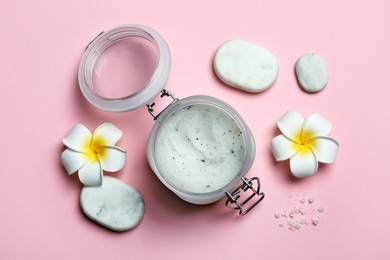 Photo of Body scrub, spa stones and plumeria flowers on pink background