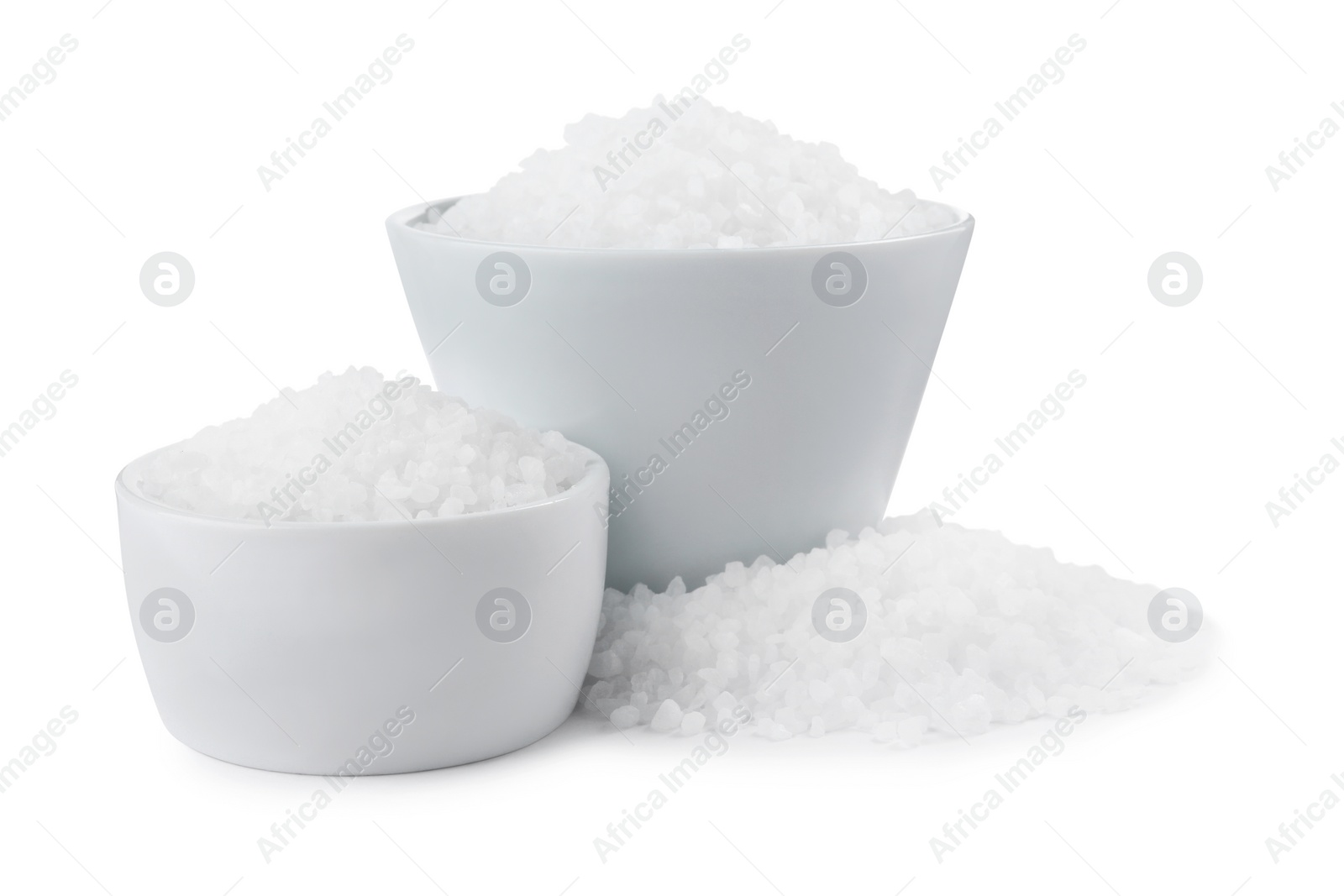 Photo of Ceramic bowls with natural sea salt isolated on white