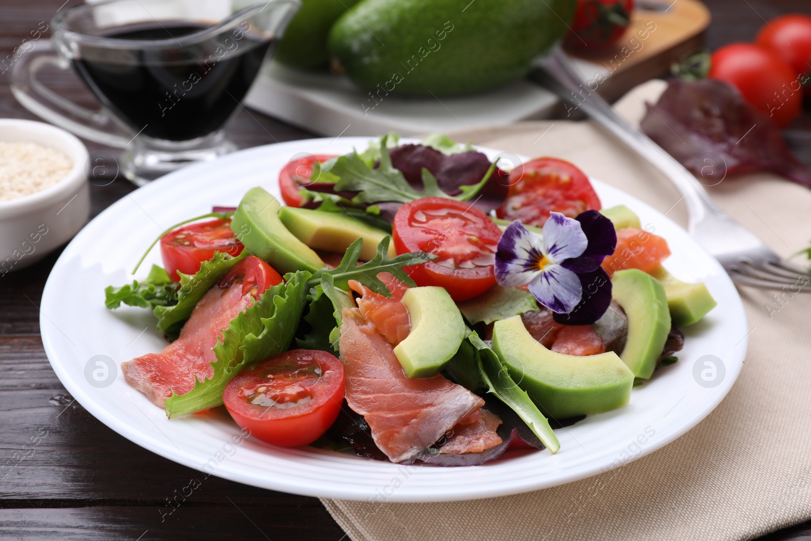 Photo of Tasty vegetable salad with soy sauce served on wooden table, closeup