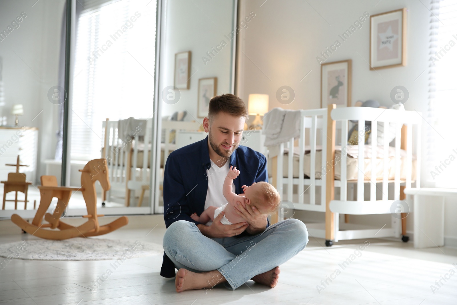 Photo of Father with his newborn son at home