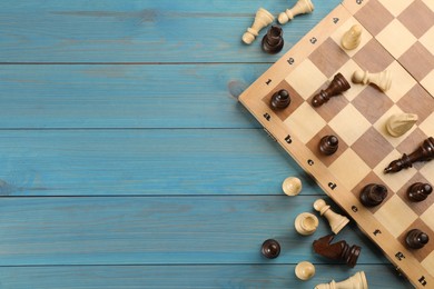 Photo of Flat lay composition of chess on light blue wooden table, space for text. Board game