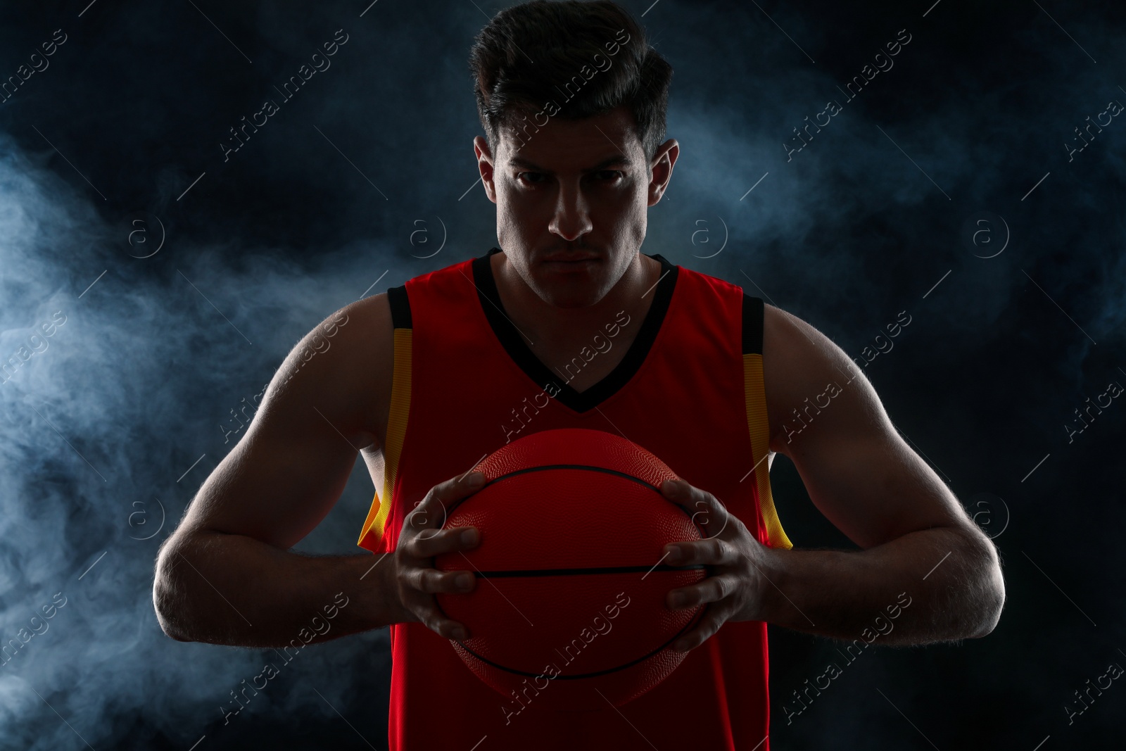 Photo of Basketball player with ball on black background