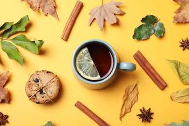 Photo of Flat lay composition with cup of hot drink on yellow background. Cozy autumn atmosphere