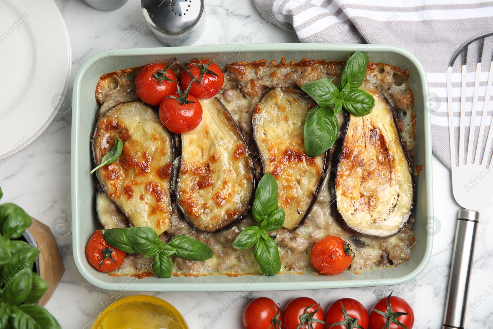 Photo of Delicious eggplant lasagna in baking dish on white marble table, flat lay