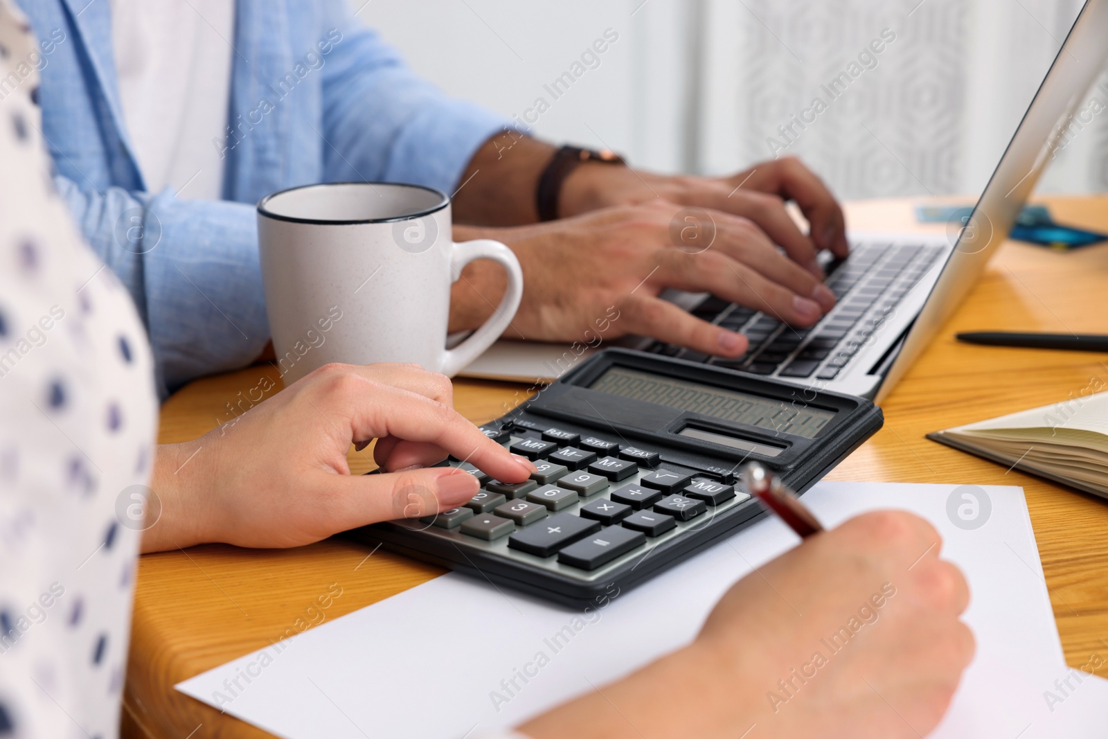 Photo of Young couple discussing family budget at table, closeup