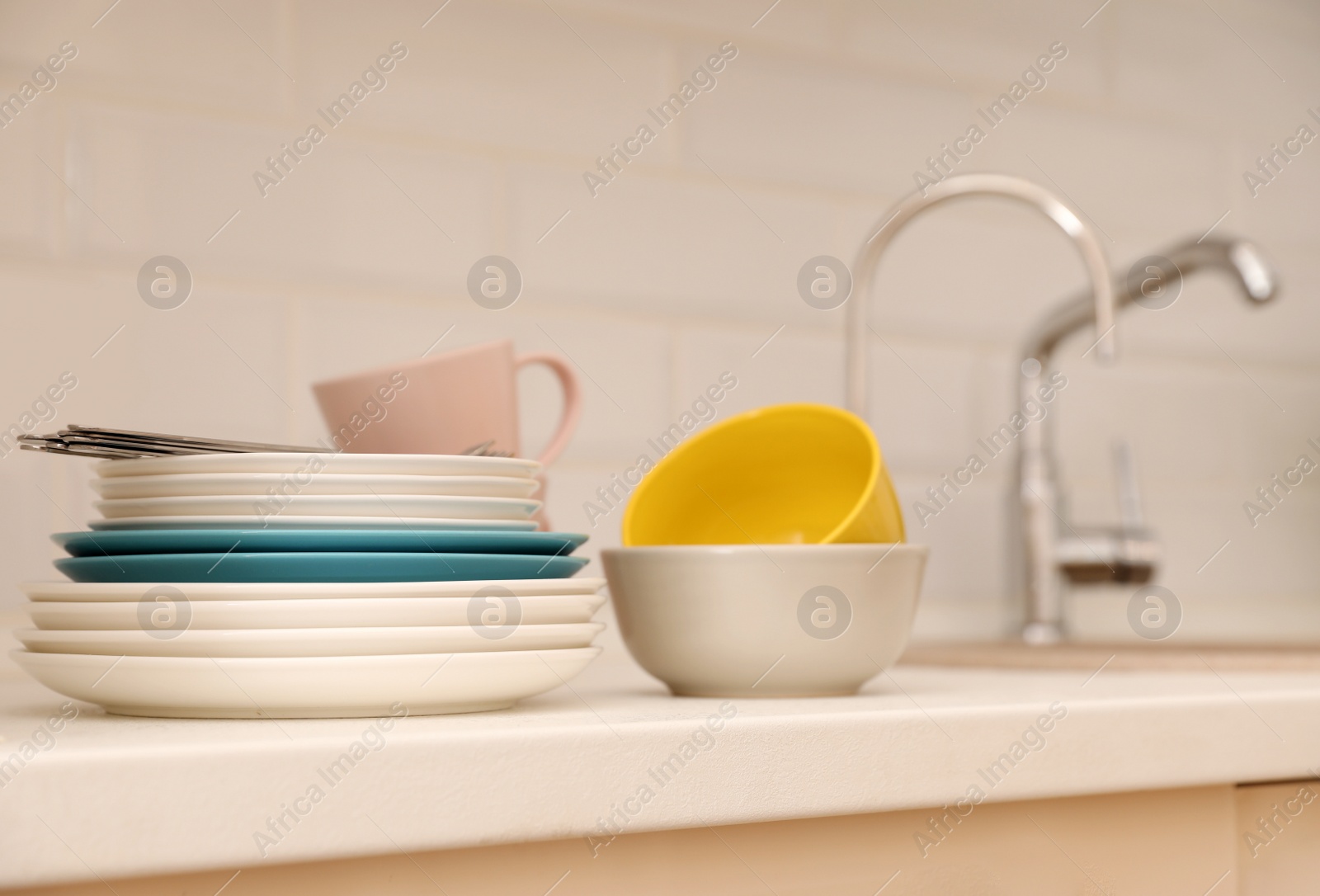 Photo of Clean dishware and cutlery on counter near kitchen sink