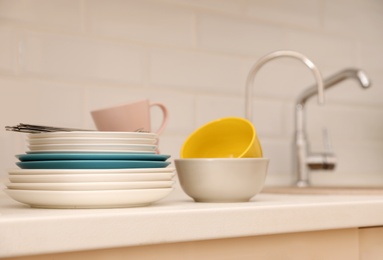 Photo of Clean dishware and cutlery on counter near kitchen sink