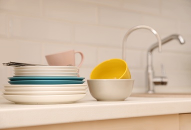 Clean dishware and cutlery on counter near kitchen sink