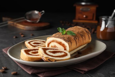 Photo of Tasty cake roll with jam and mint on grey table