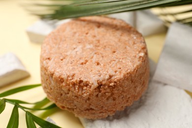 Solid shampoo bar and leaf on beige table, closeup. Hair care