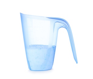 Photo of Laundry detergent in plastic measuring cup on white background