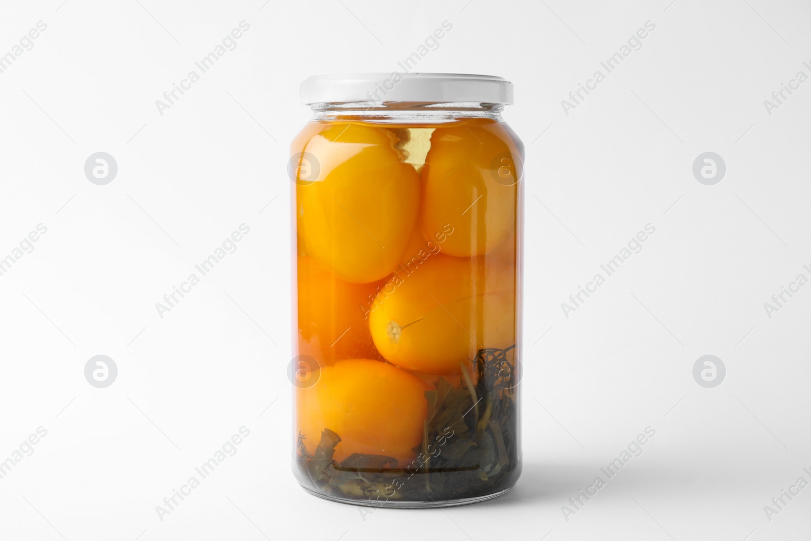 Photo of Jar of pickled yellow tomatoes on white background