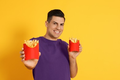 Photo of Man with French fries on orange background