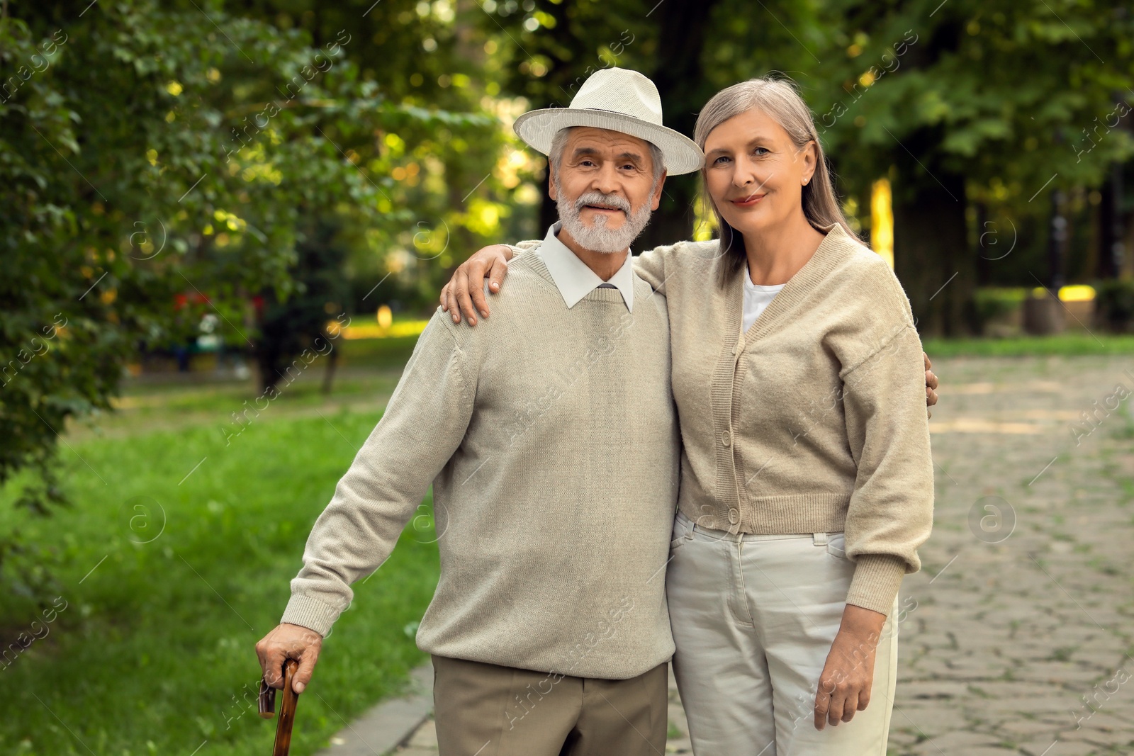 Photo of Senior man with walking cane and mature woman in park