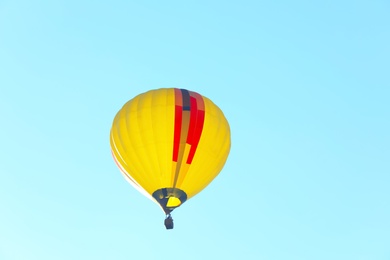 Photo of Colorful hot air balloon flying in blue sky. Space for text