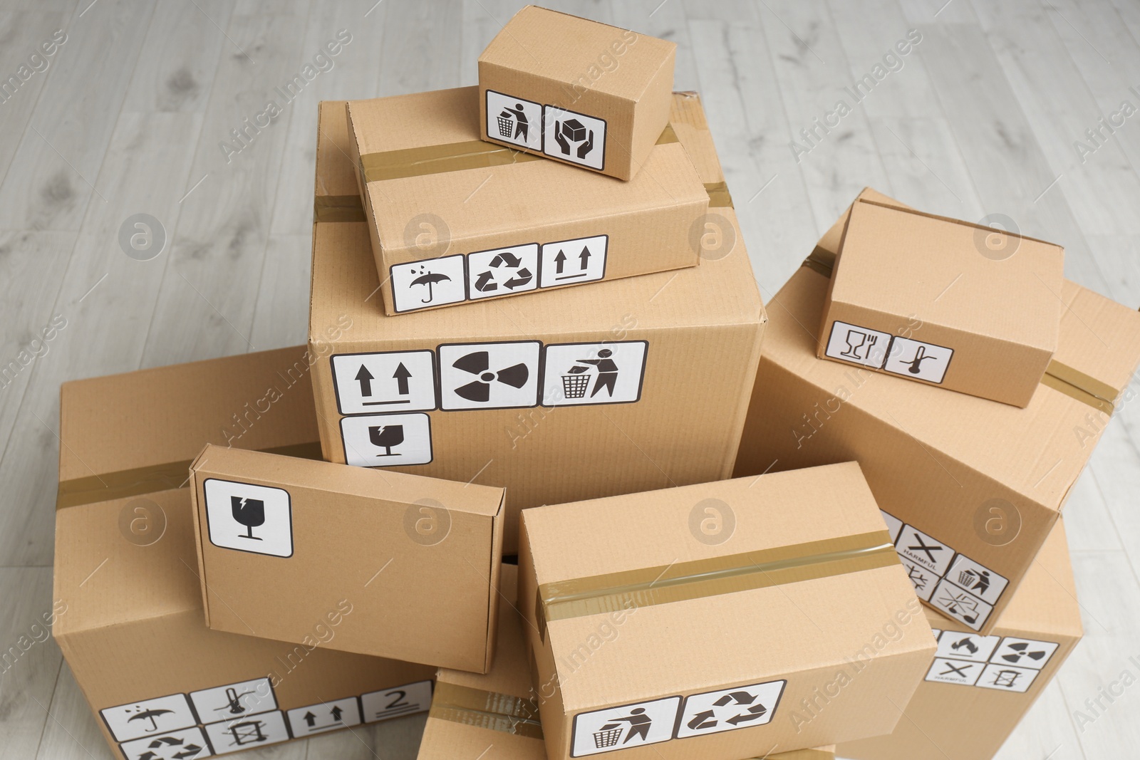 Photo of Cardboard boxes with different packaging symbols on floor, above view. Parcel delivery