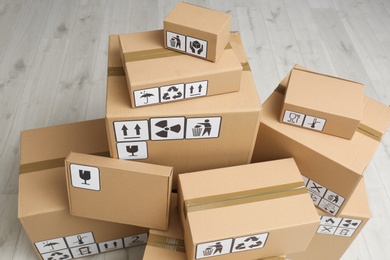 Photo of Cardboard boxes with different packaging symbols on floor, above view. Parcel delivery