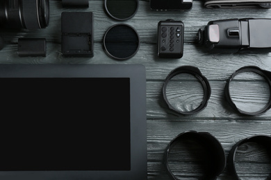 Flat lay composition with equipment for professional photographer on grey wooden table