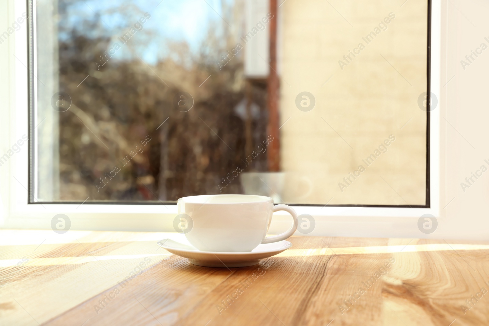 Photo of Cup of hot winter drink on wooden windowsill, space for text