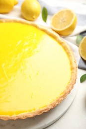 Photo of Delicious homemade lemon pie and fresh fruits on light table, closeup