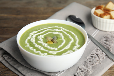 Photo of Delicious broccoli cream soup served on wooden table