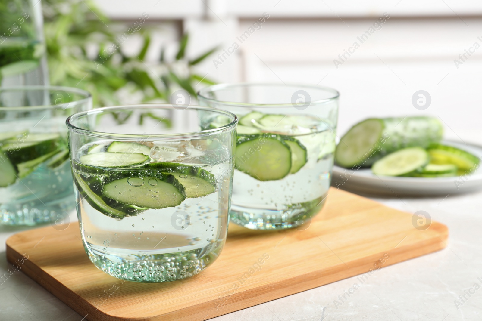 Photo of Glasses of fresh cucumber water on table. Space for text