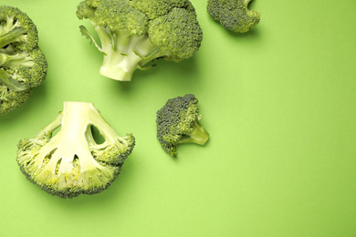 Photo of Fresh broccoli on green background, flat lay. Space for text