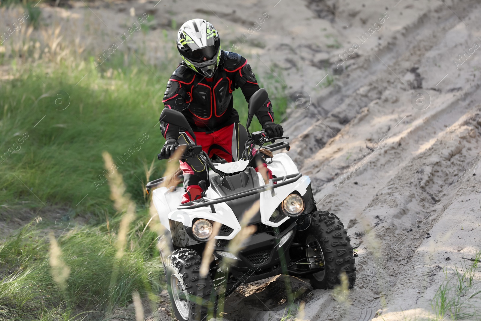 Photo of Man driving modern quad bike on sandy road. Extreme sport