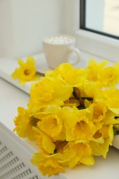 Bouquet of beautiful daffodils on white windowsill