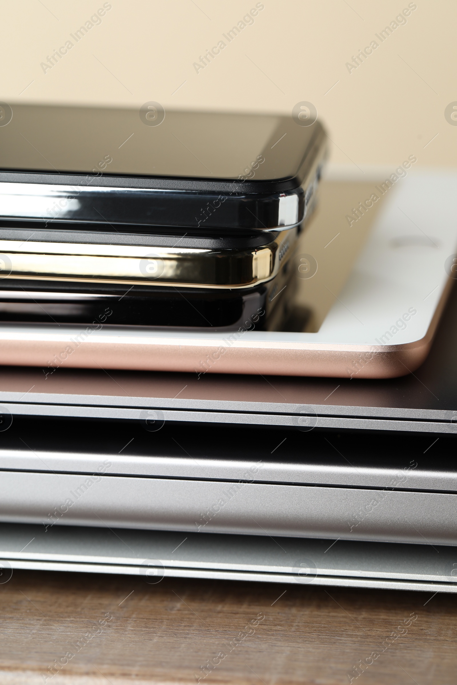 Photo of Stack of electronic devices on wooden table, closeup