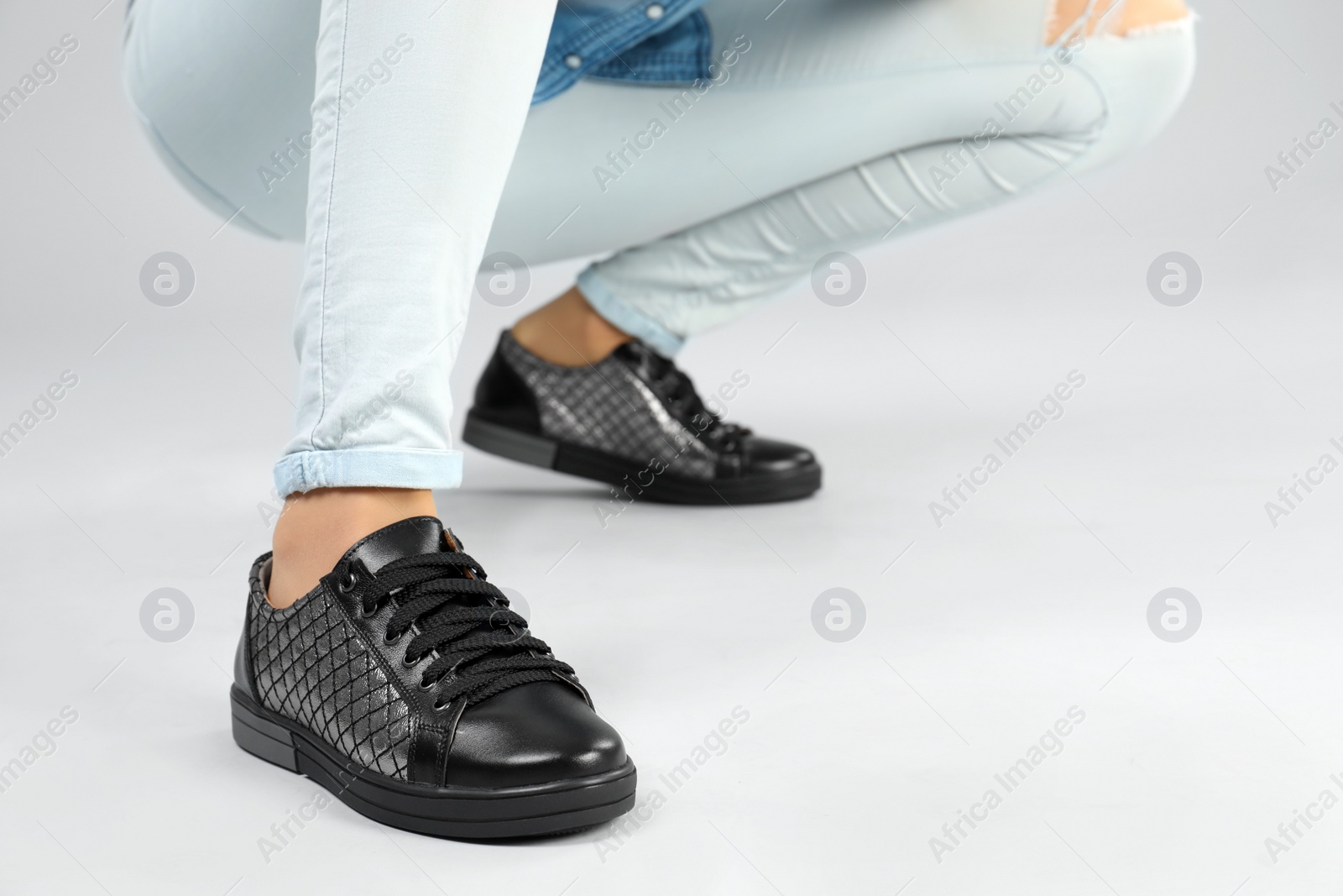Photo of Woman in stylish shoes on grey background, closeup. Space for text