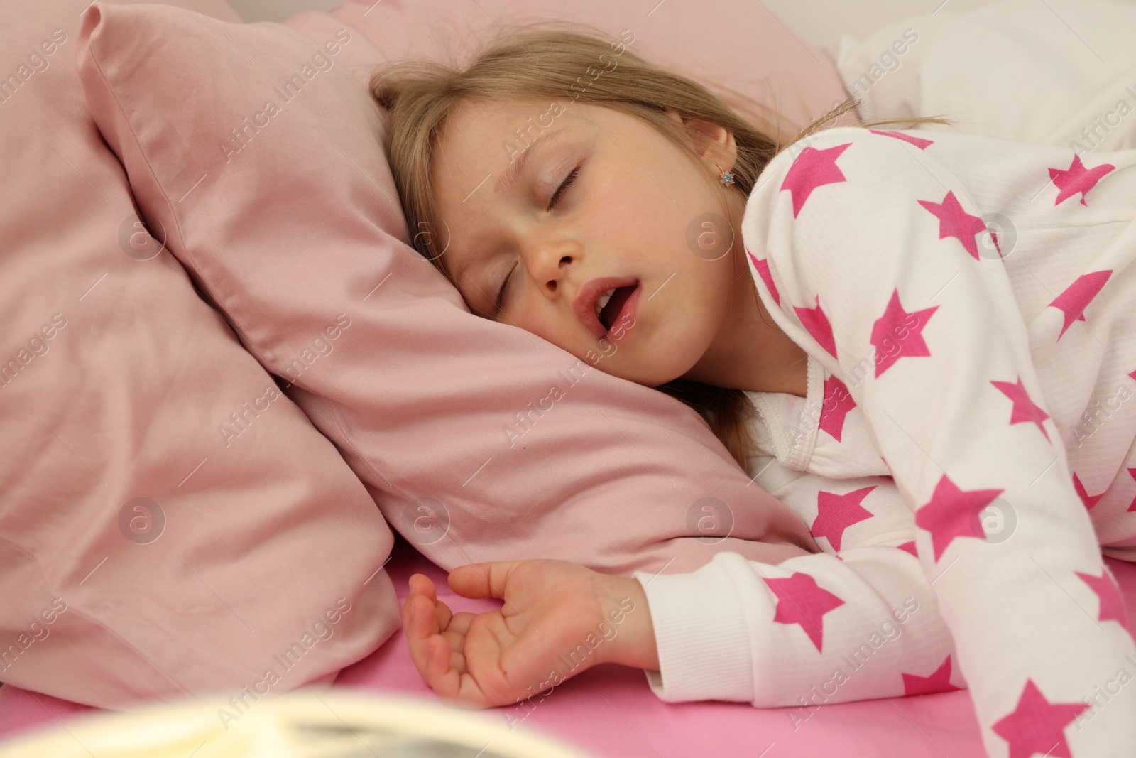 Photo of Little girl snoring while sleeping in bed