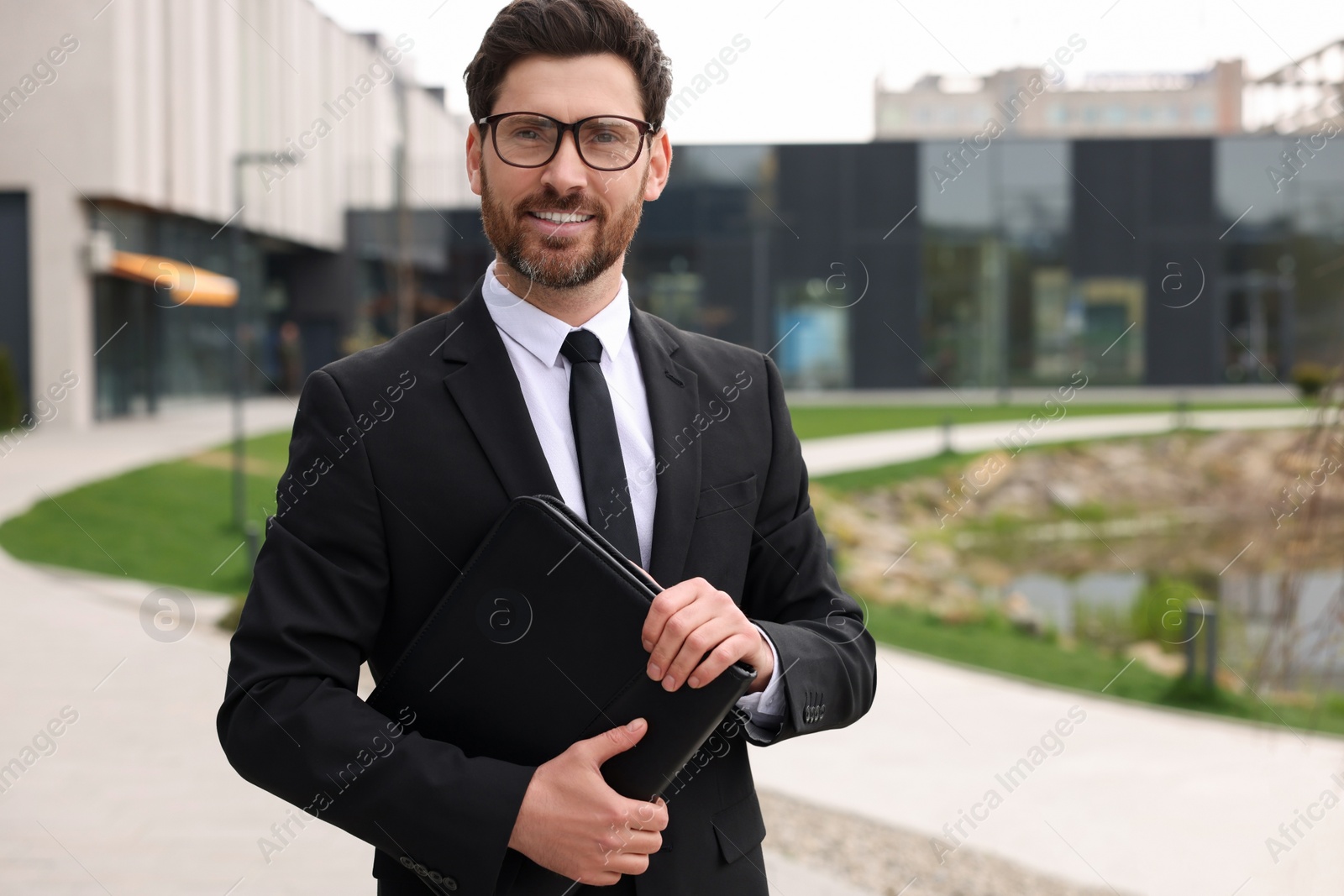 Photo of Real estate agent with leather portfolio outdoors. Space for text