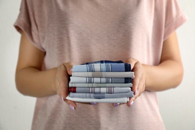Photo of Woman holding many different handkerchiefs on white background, closeup