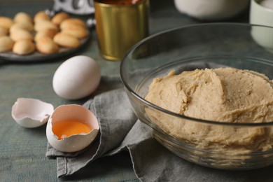 Photo of Dough for walnut shaped cookies and eggs on wooden table, closeup