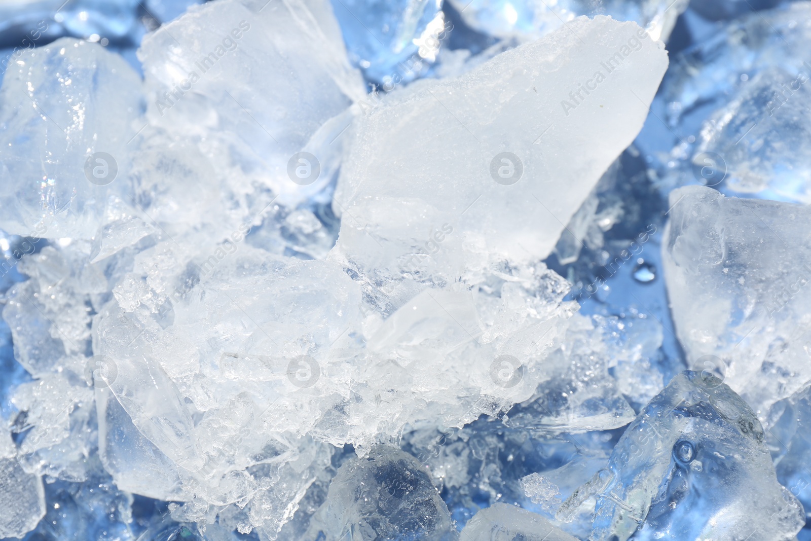 Photo of Pieces of crushed ice on light blue background, above view