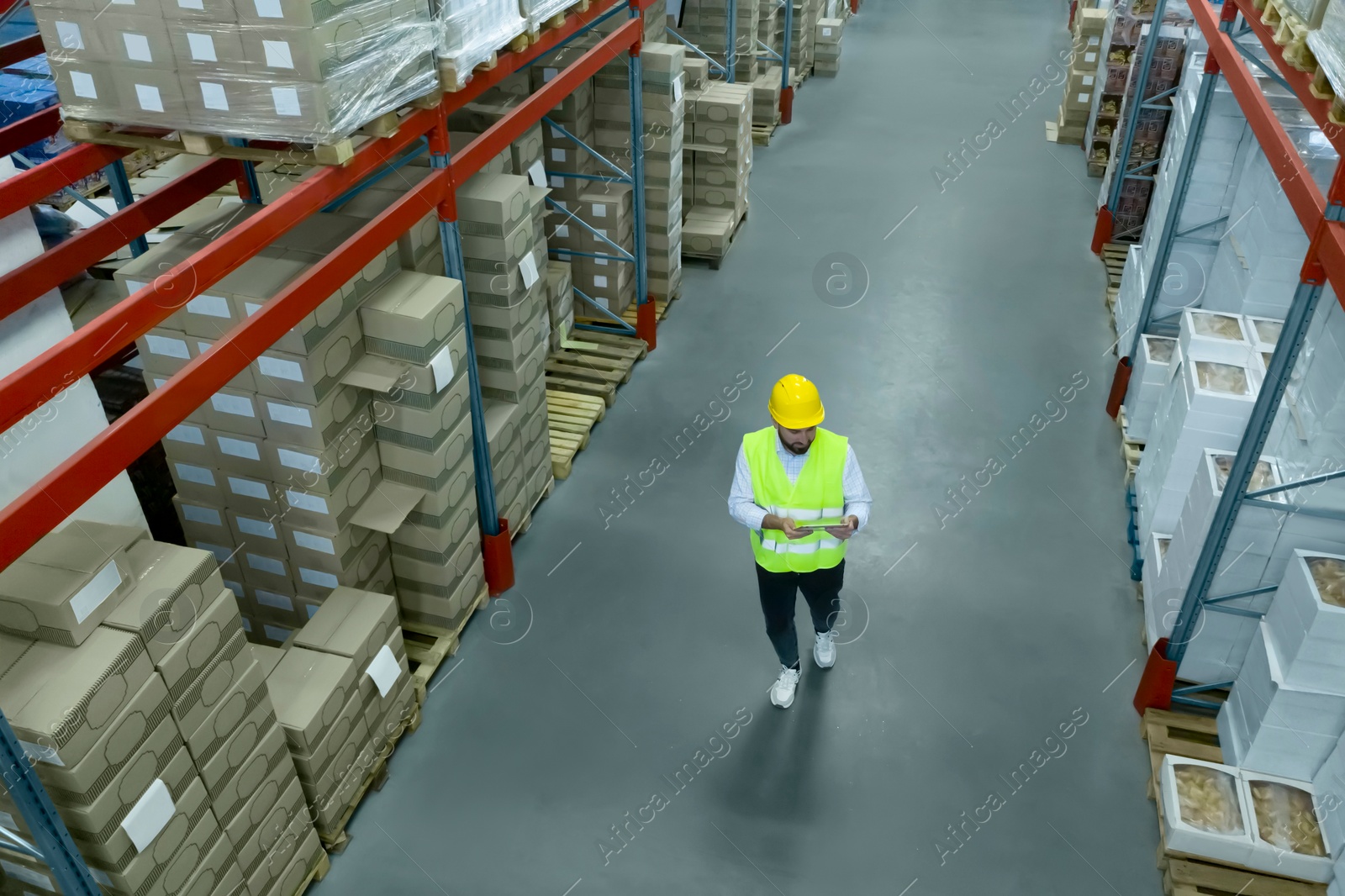 Image of Man with tablet working at warehouse, above view. Logistics center