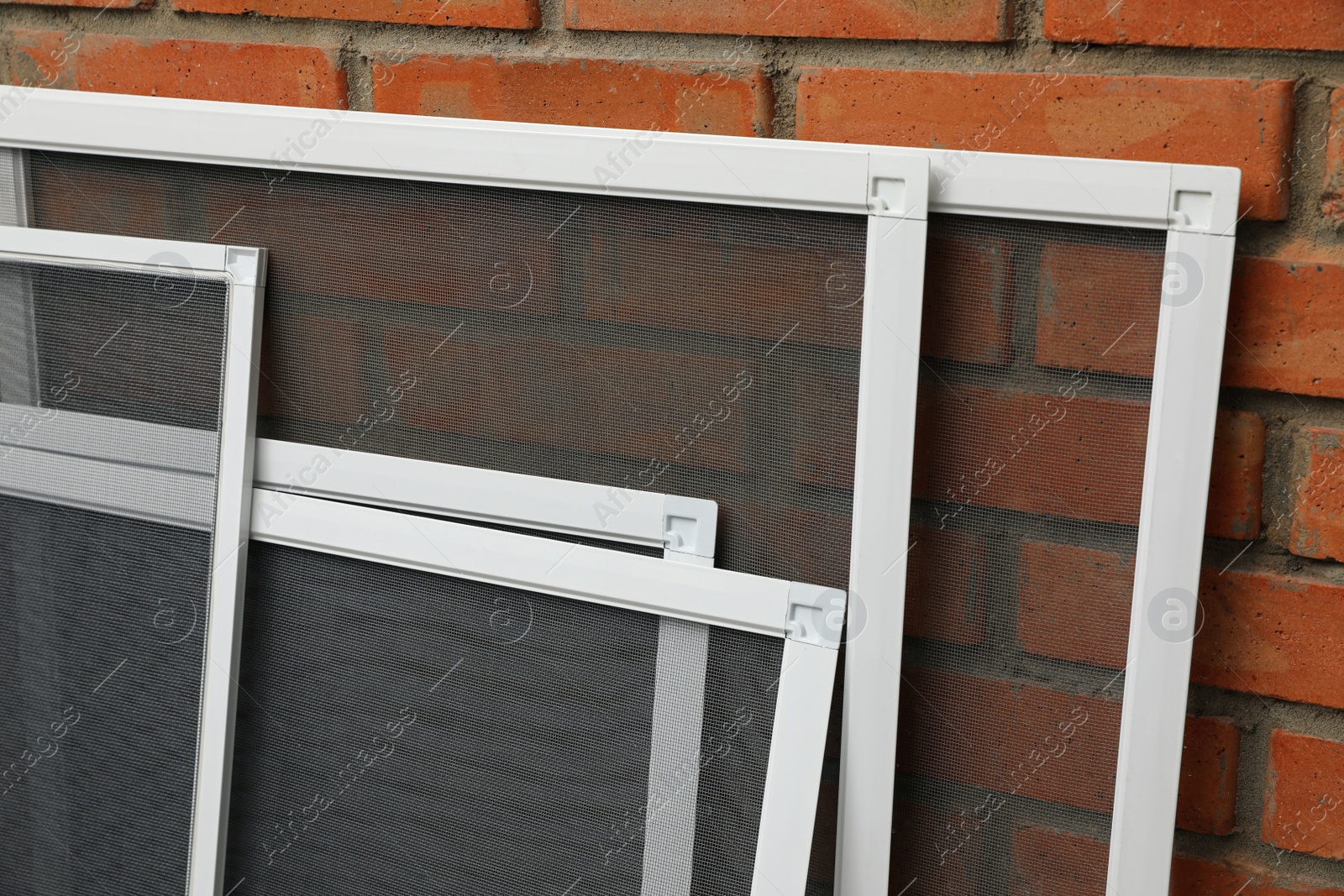 Photo of Set of window screens near brick wall