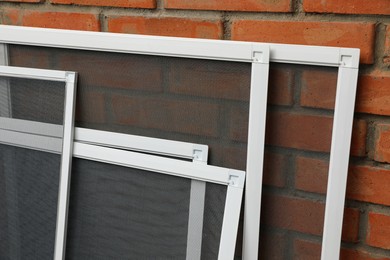 Set of window screens near brick wall