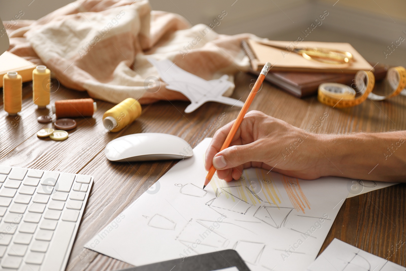 Photo of Male fashion designer working at wooden table, closeup