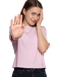 Photo of Embarrassed young woman covering face with hand on white background