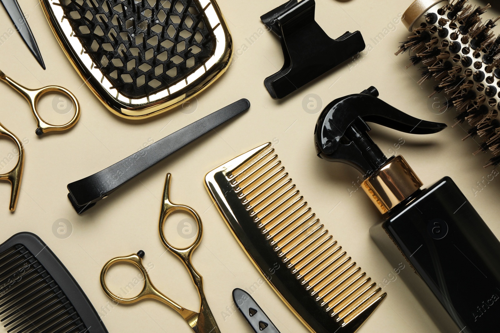 Photo of Different hairdresser tools on beige background, flat lay