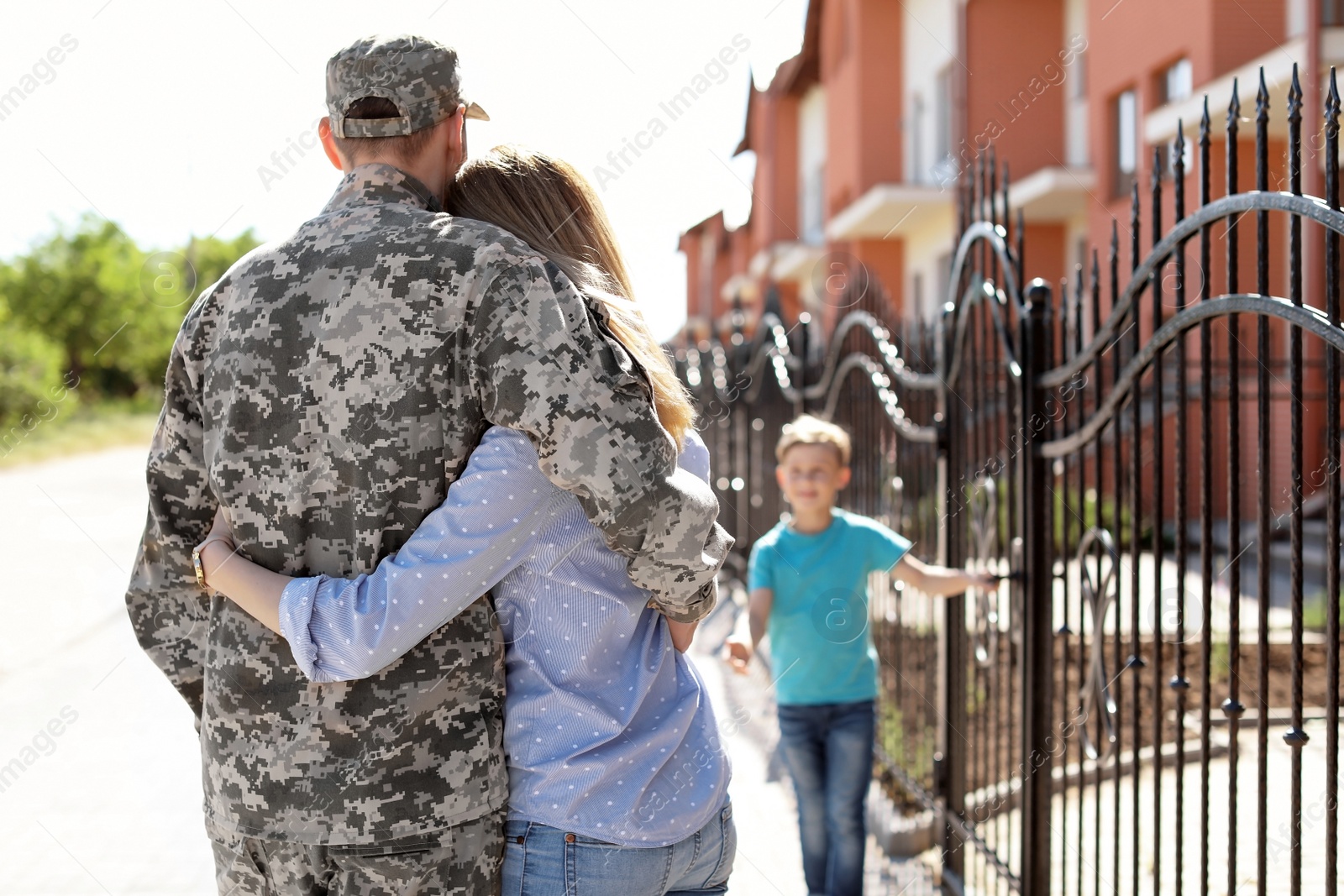 Photo of Soldier in military uniform with his family outdoors