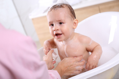 Photo of Mother with her little baby in bathroom