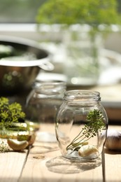 Photo of Empty glass jar and ingredients prepared for canning on wooden table indoors