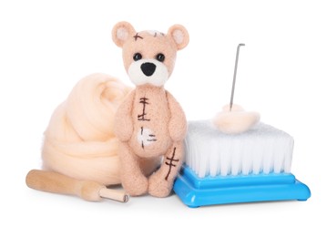 Needle felted bear, wool and tools isolated on white