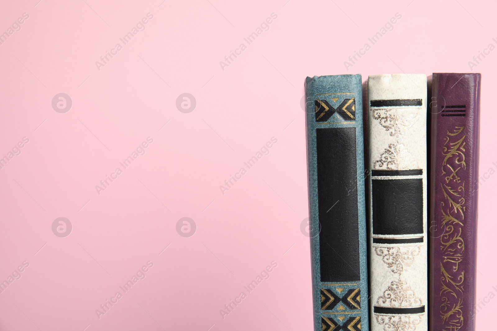 Photo of Old books on pink background, space for text